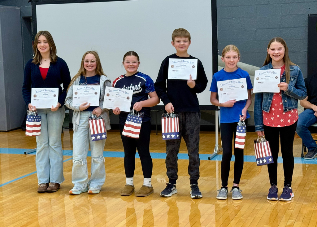The middle school students are standing with their awards for the Patriots Pen essay.