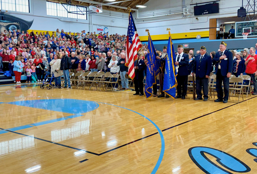 The crowd is shown from the program. There are five soldiers holding the flags.