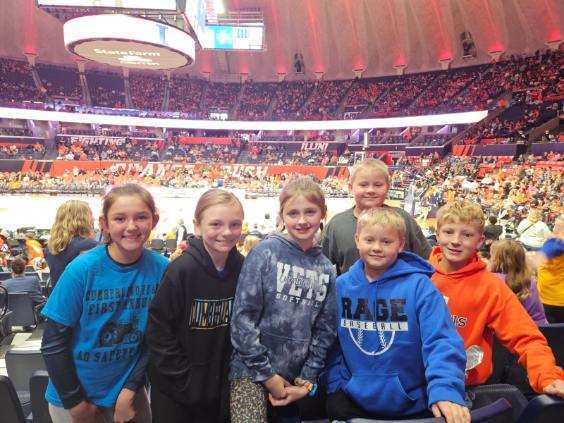 A group of six students is standing together for a picture. The court is in the background. 