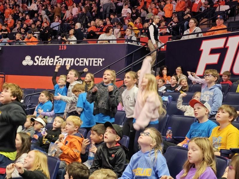 Students in are cheering because they noticed they are on the jumbo screen. 