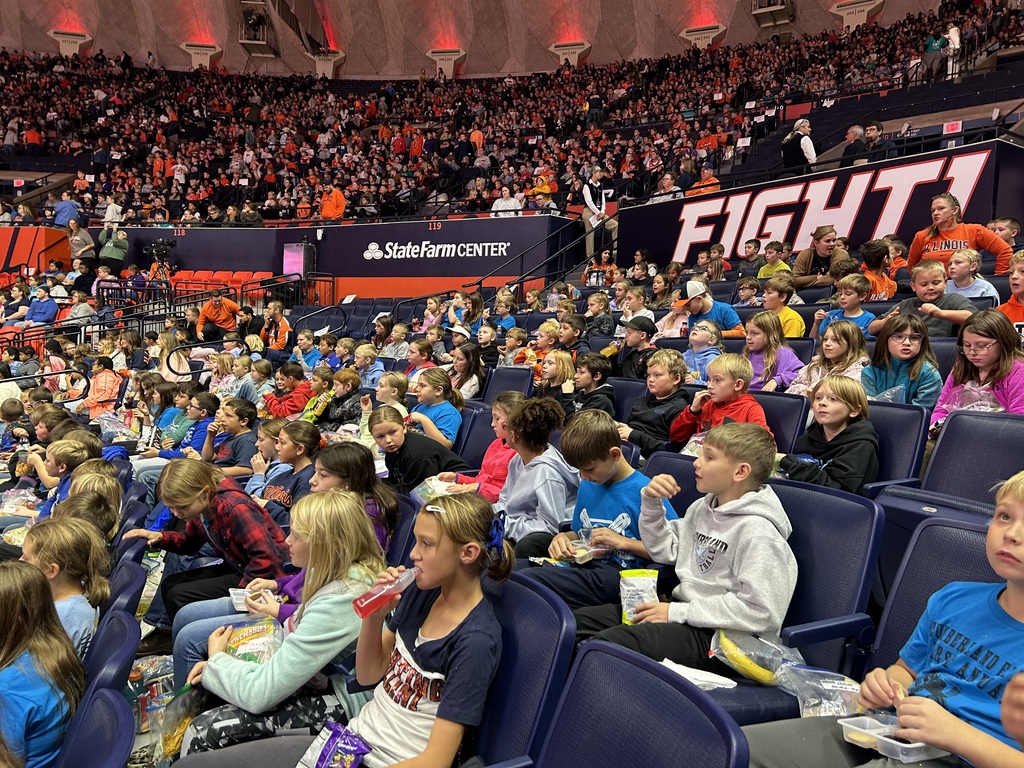 Students are sitting in the stands eating their snacks. 