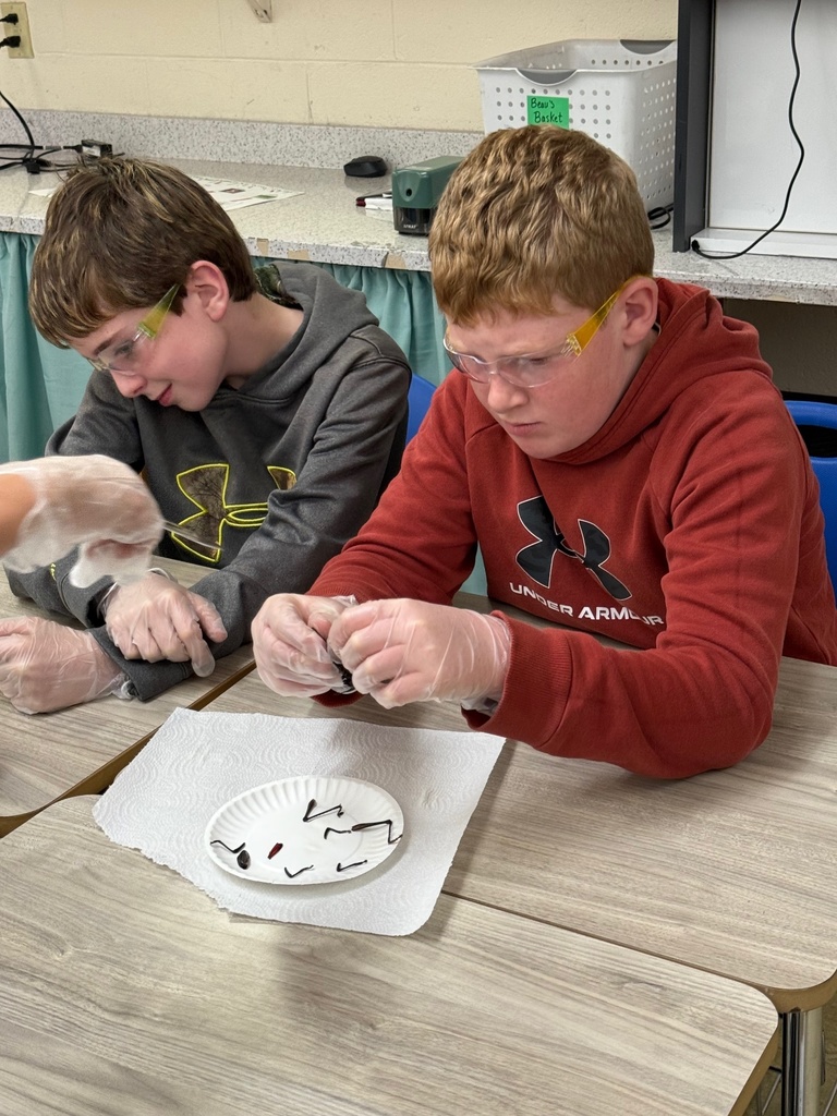 Two students are cutting the legs off of the specimen. 
