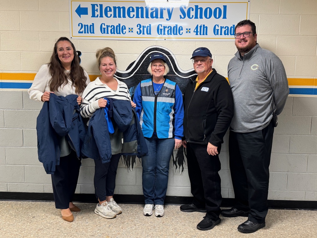 Pictured are the two principals, guidance counselor, and Paul and Keri Marti. They are holding a few of hte coats, hats, and socks to be distributed.