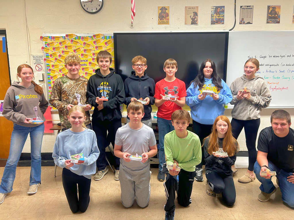 This is a group picture. Each student is holding their volcano. 