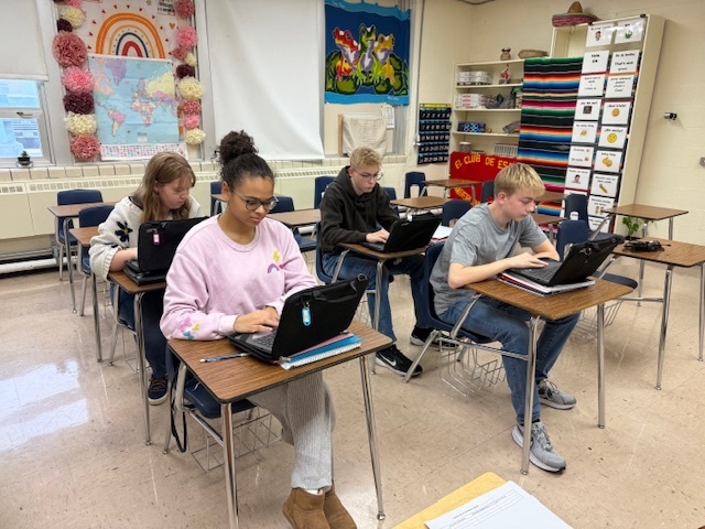 Students are sitting at their desks playing Matamoscas on their Chromebooks.