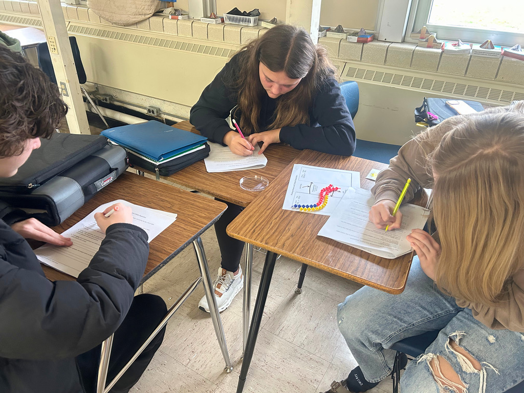 Students are sitting at desks. They are writing in their packets.