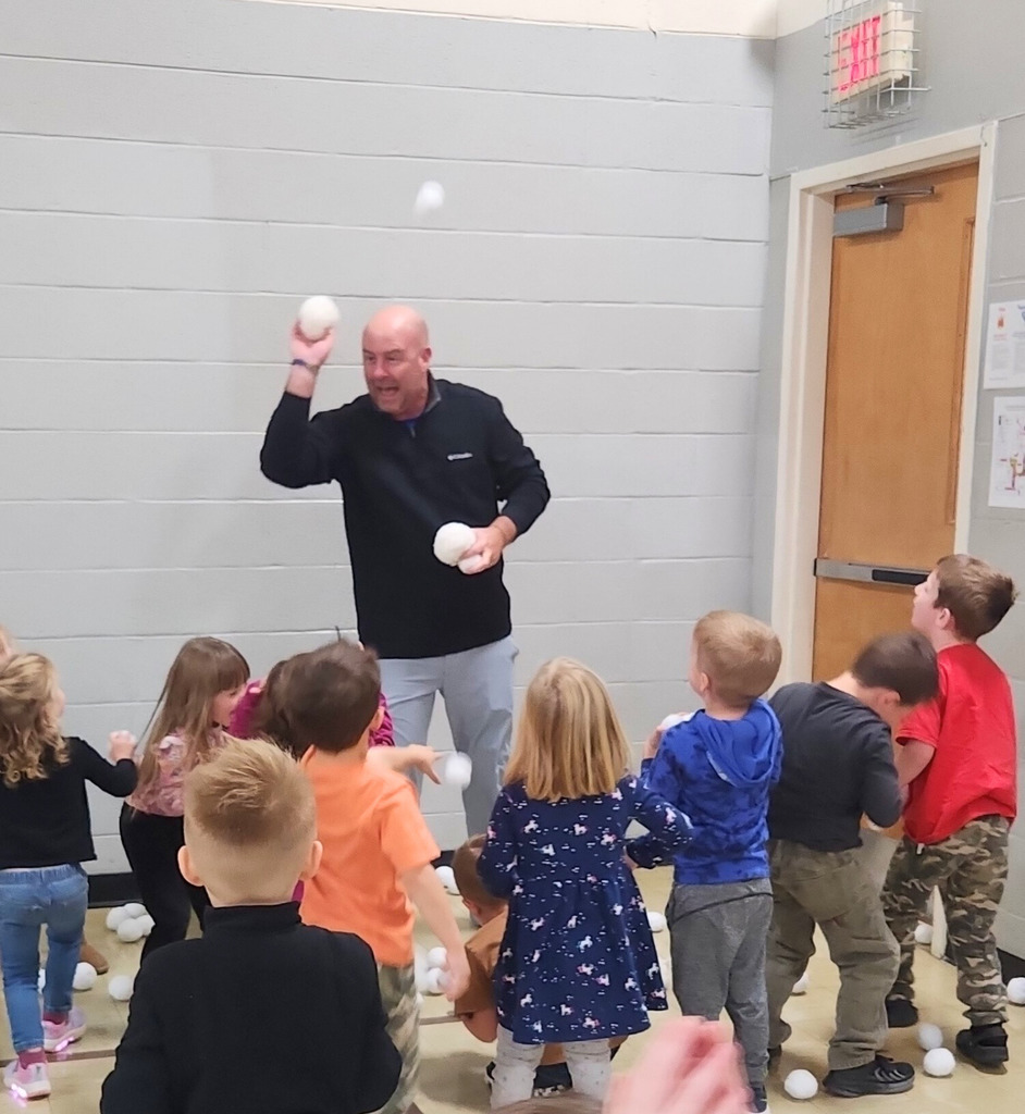 The preschool students are ganging up on Mr. Houchin and throwing "Snowballs" at him.Hes dodging and throwing them back.