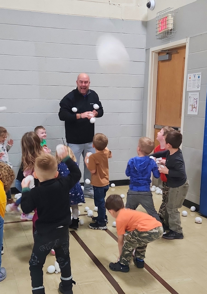 The preschool students are ganging up on Mr. Houchin and throwing "Snowballs" at him.Hes dodging and throwing them back.