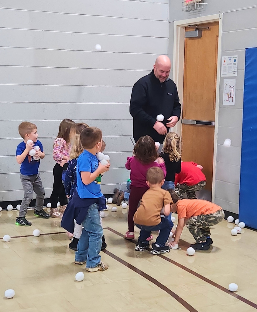 The preschool students are ganging up on Mr. Houchin and throwing "Snowballs" at him.Hes dodging and throwing them back.