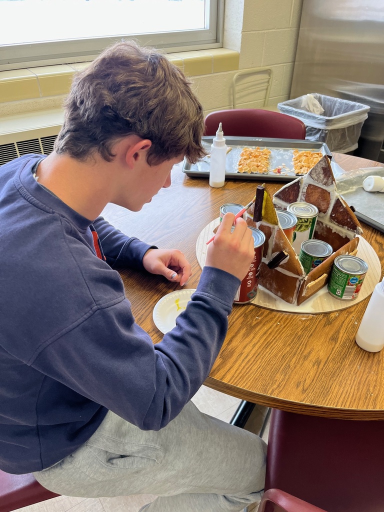 A student is building the walls of the gingerbread house.