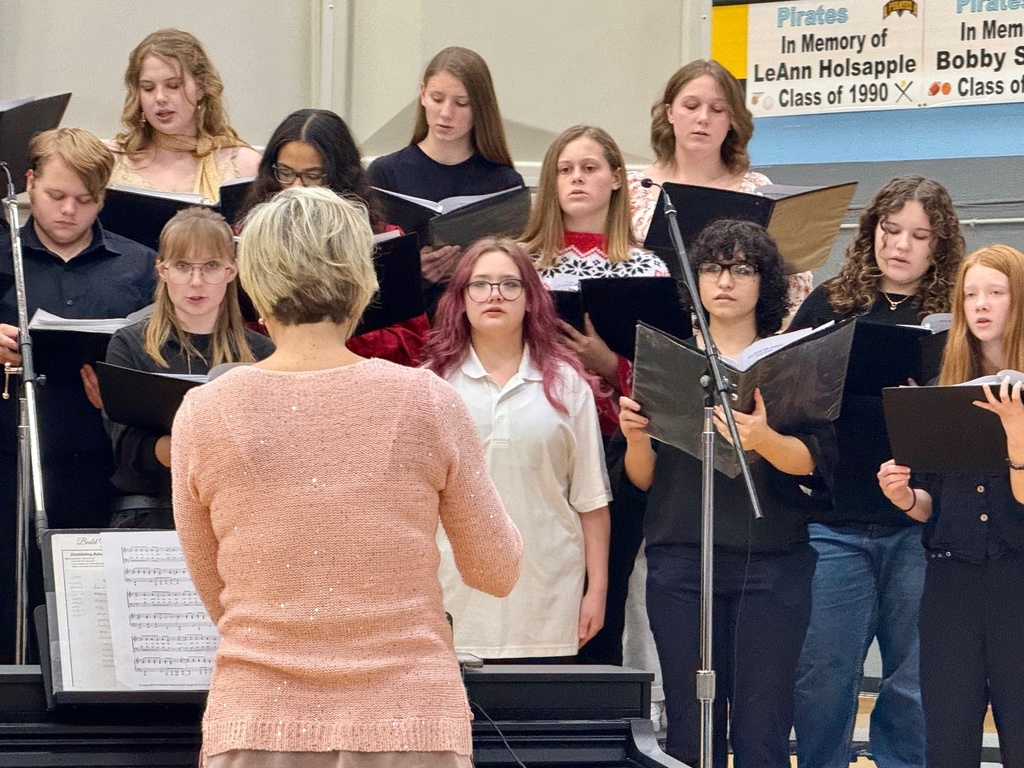 The image shos a third of the choir on the rafters singing from a black binder.
