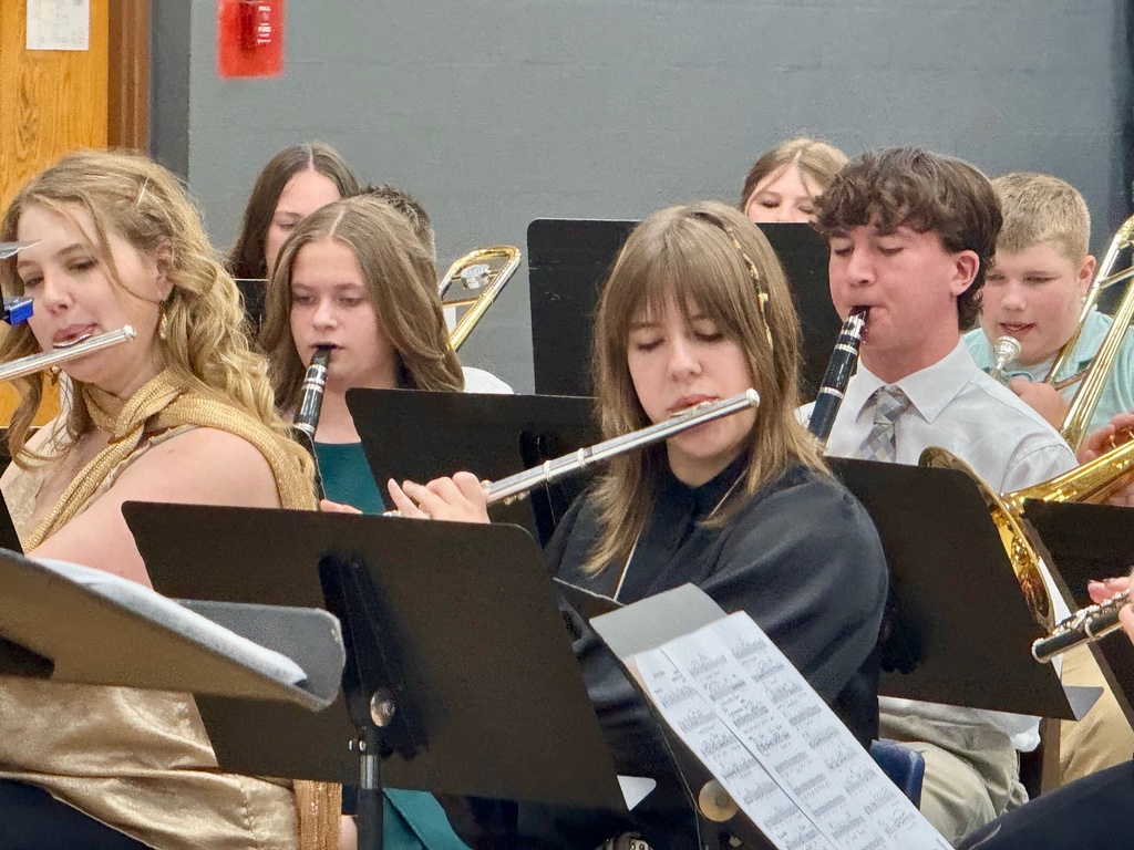 The image shows the woodwind section of the band playing from music on a music stand.