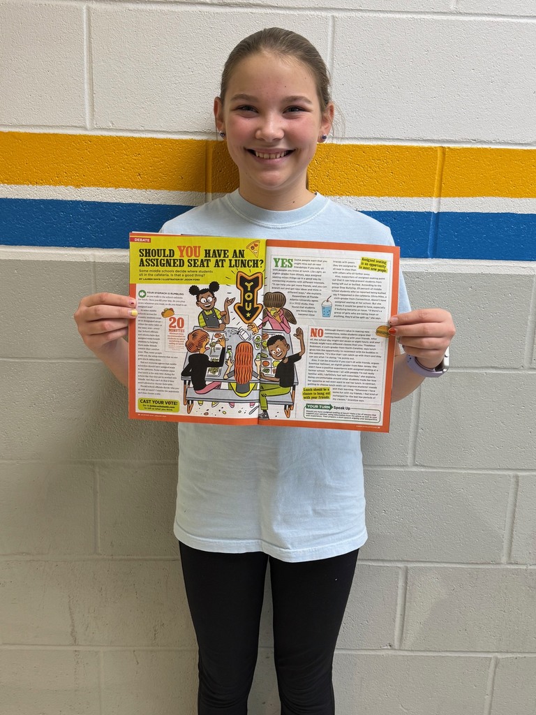 The student is pictured holding the magazine open to the article where she is quoted.