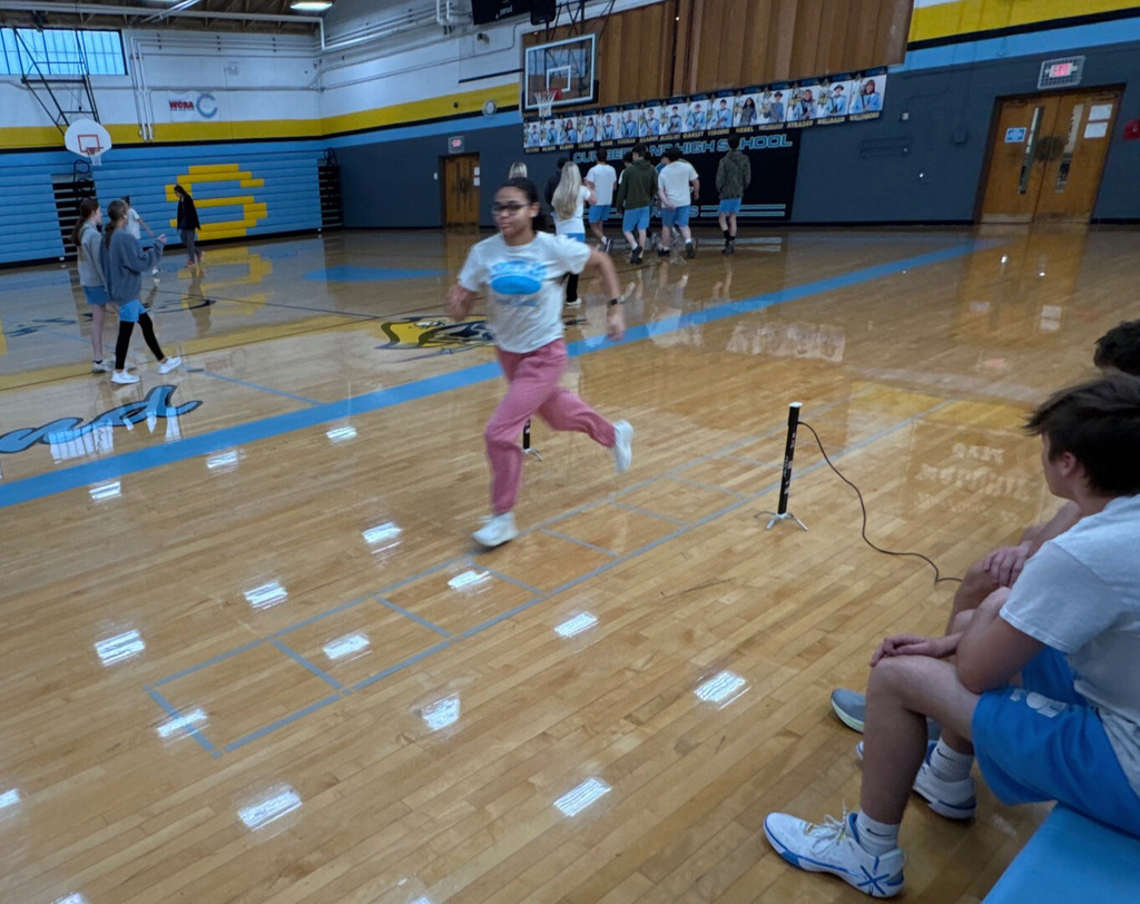 The student is running a portion of the shuttle run. The student is running between two sensors to one end of the run. 