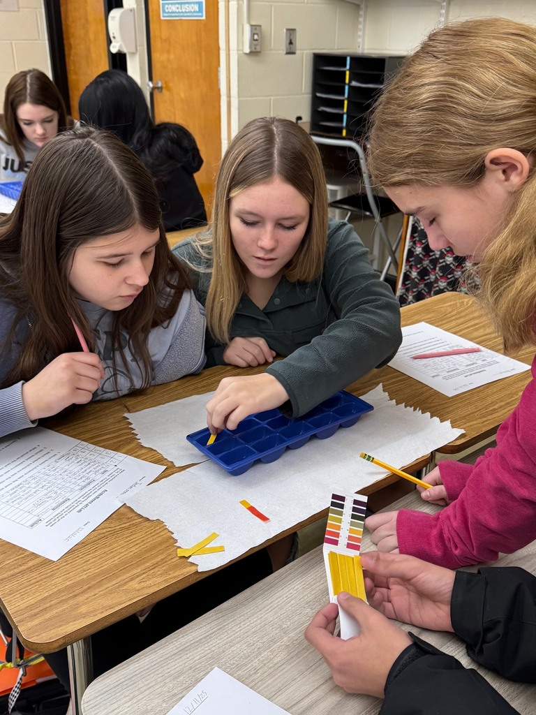 A student is dipping a pH strip in to a liquid and checking its color. 