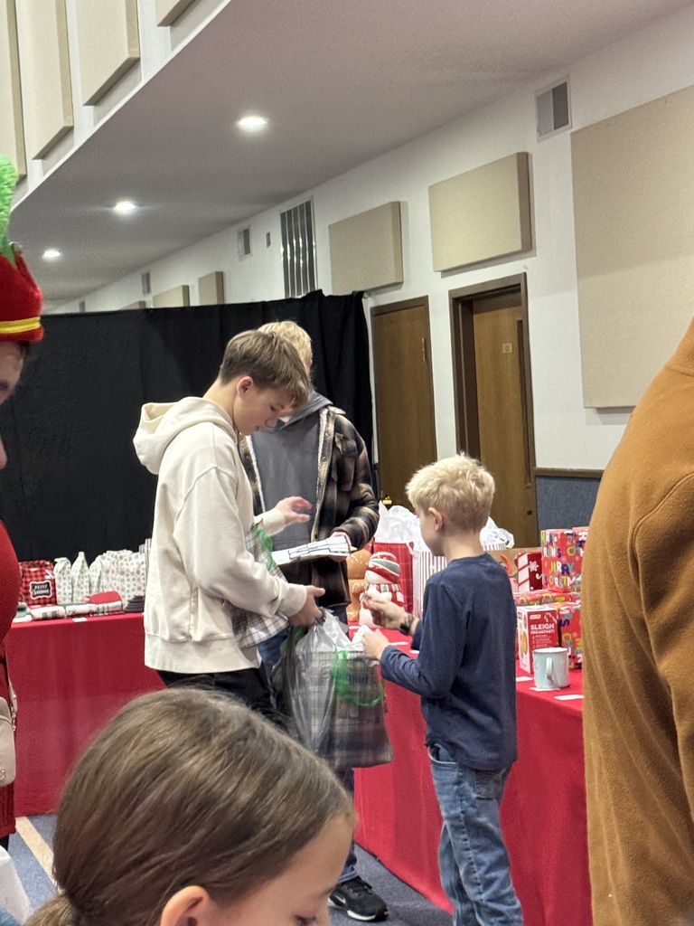 The NHS students are helping the younger children select gifts at the Mouse House.