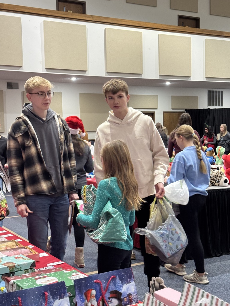 The NHS students are helping the younger children select gifts at the Mouse House.