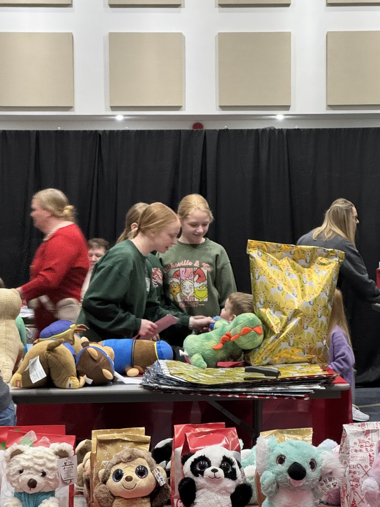 The NHS students are helping the younger children select gifts at the Mouse House.