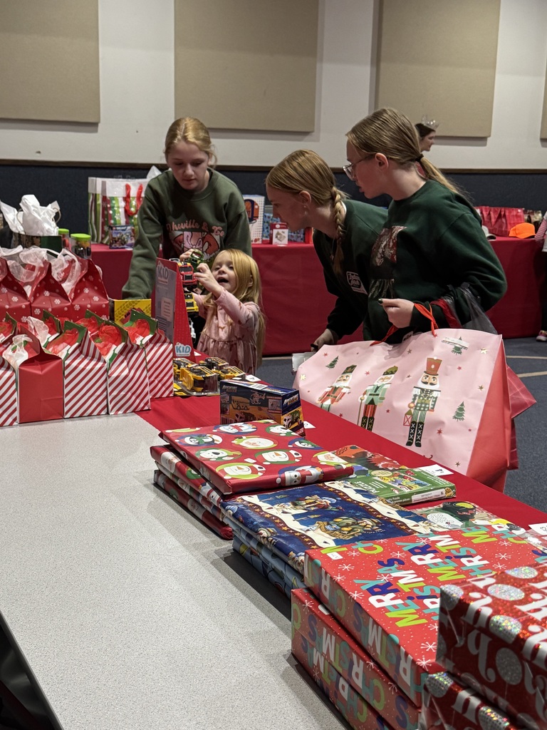 The NHS students are helping the younger children select gifts at the Mouse House.