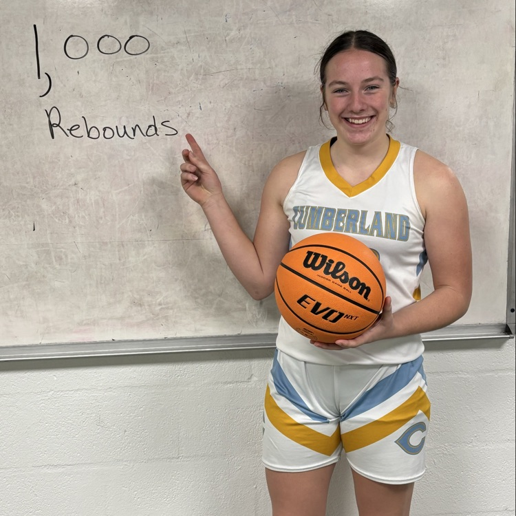 AD is holding the game ball and pointing to the white board that says 1,000 rebounds