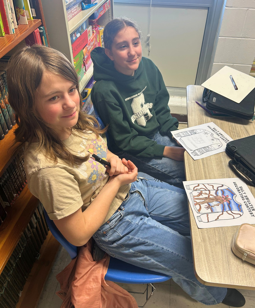Student are sitting at their desk designing their sweaters to look like holiday designs.