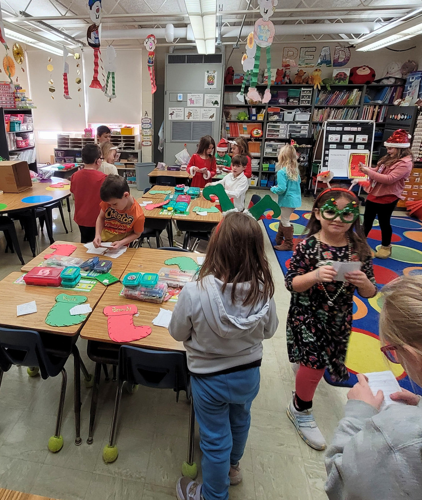 Students are walking around the classroom delivering their kindness letters. 