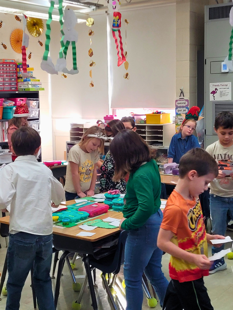 Students are walking around the classroom delivering their kindness letters. 