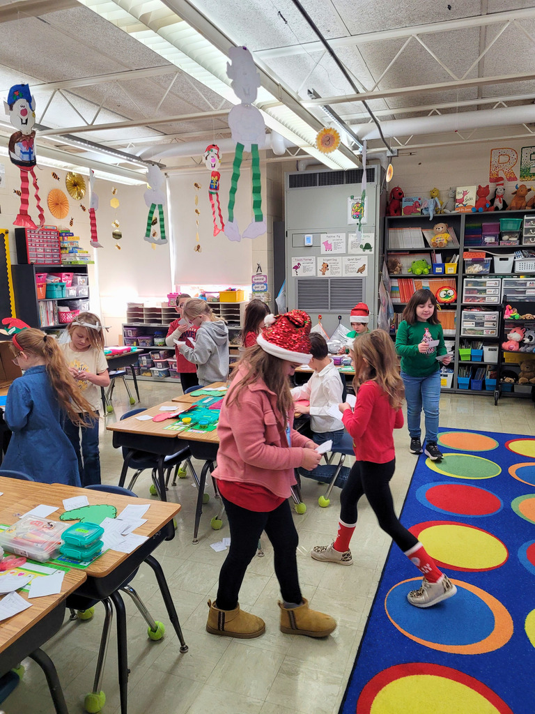 Students are walking around the classroom delivering their kindness letters. 