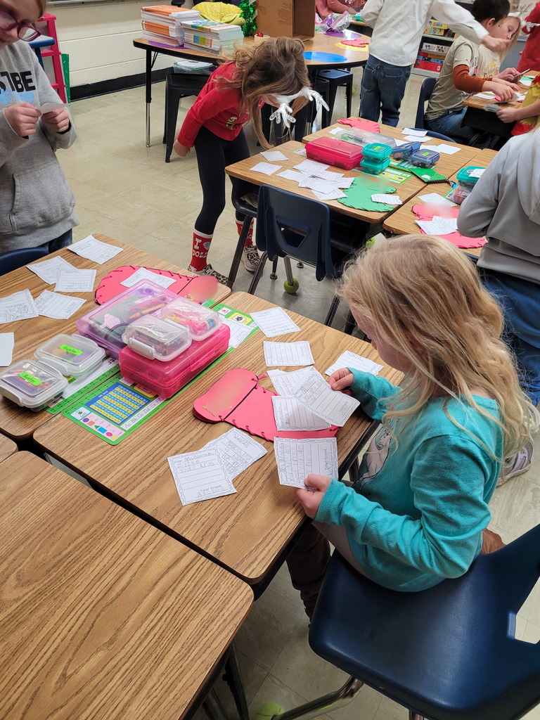 A student is sitting at her desk reading the messages fhat were placed in her stocking. 