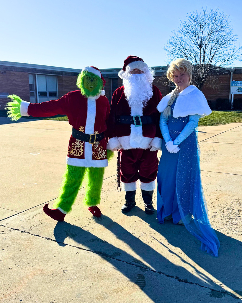 The Grinch, Santa, and Elsa are standing outside of the school. 