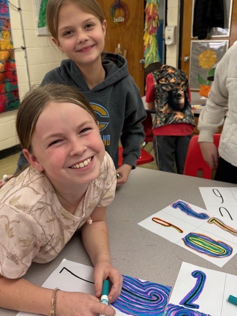 Students are creating line art. They are drawing lines around the numbers 2026.