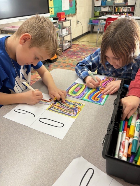 Students are creating line art. They are drawing lines around the numbers 2026.