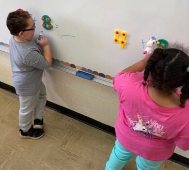 Two students are practicing math facts. They are using touchpoint numbers to help them figure out the answers.