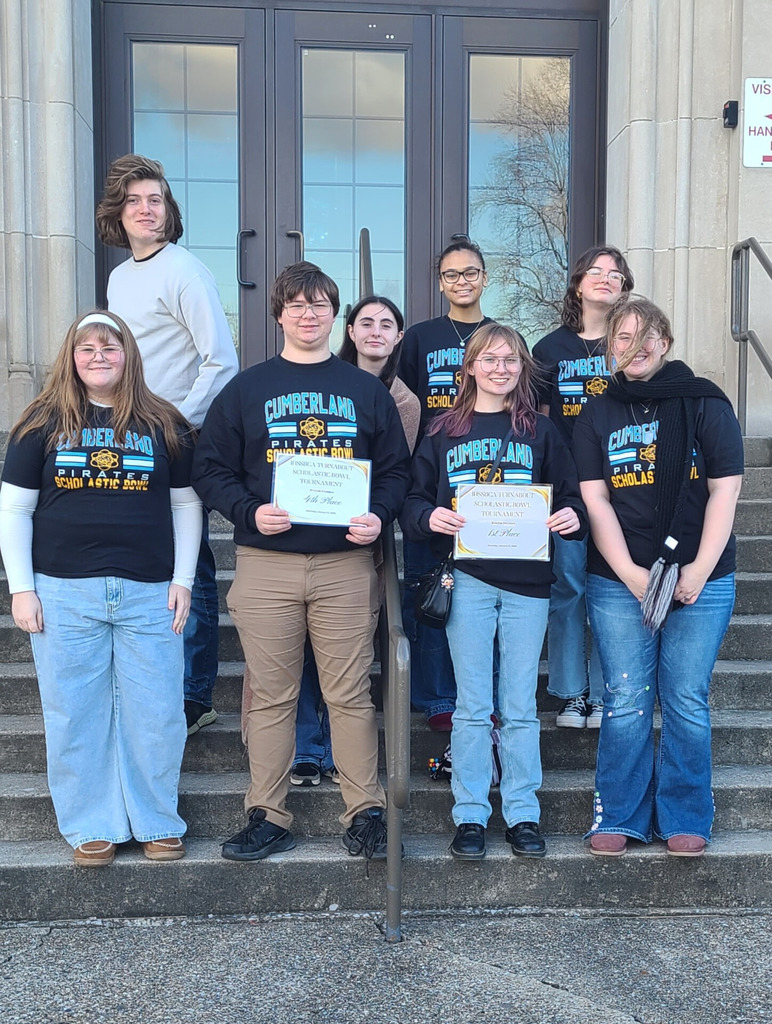 The members of the Cumberland B and C teams are standing on the steps of a builidng. They are holding two certificates. 