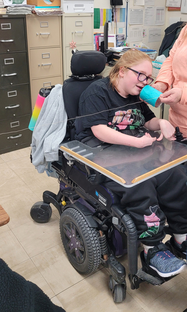 A student is talking in to her phone prototype. It is a can with string attached. 