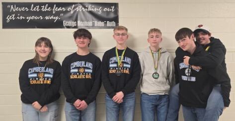 Pictured is the CHS team. Four are standing along the wall. One is on the back of another player. 