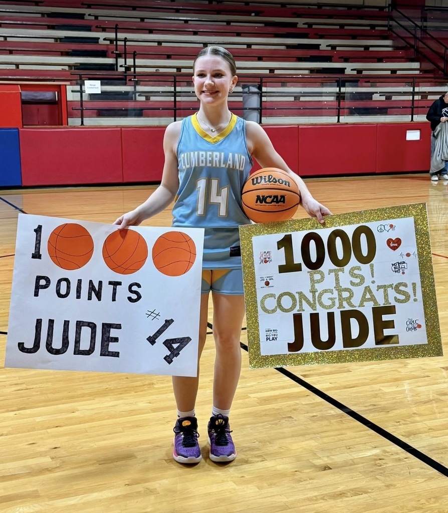 The image is of JP holding two signs and a basketball. The signs read 1000 points Jude #14 and 100 pts! Congrats Jude.