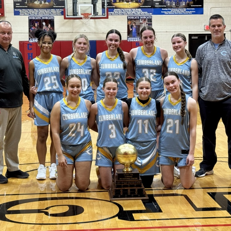Pictured is the team and coaches in two rows. They are holding the tournament trophy  