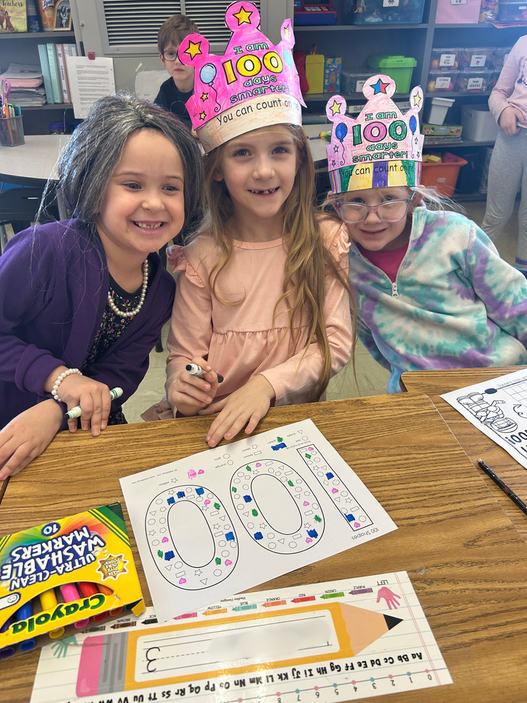 Students are completing 100 day activities. One is coloring and another is filling out a 100 sheet. 