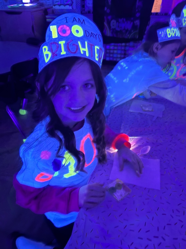 Students are sitting  in the dark. They are eating a snack.