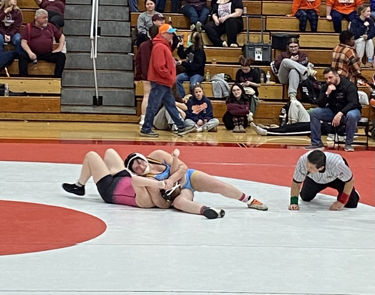 SN is in a wrestling move on the mat  