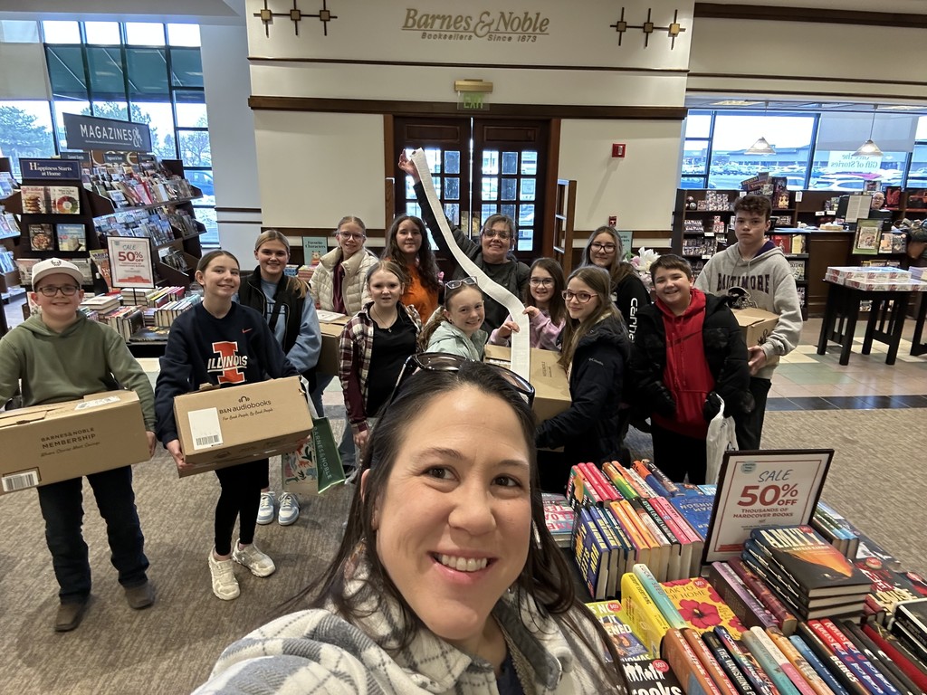 Pictured are the students and the teachers who went to Barnes and Noble. They are holding their boxes of books and the  long receipt of their purchase. 
