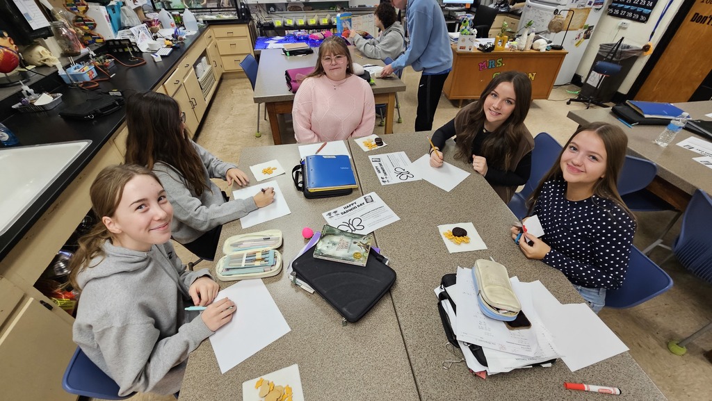 Students are coloring butterflies and eating animal snacks. 
