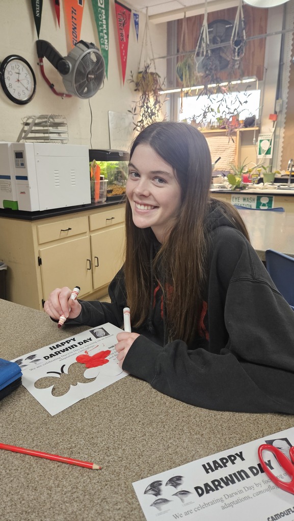 A student is coloring a butterfly red. 