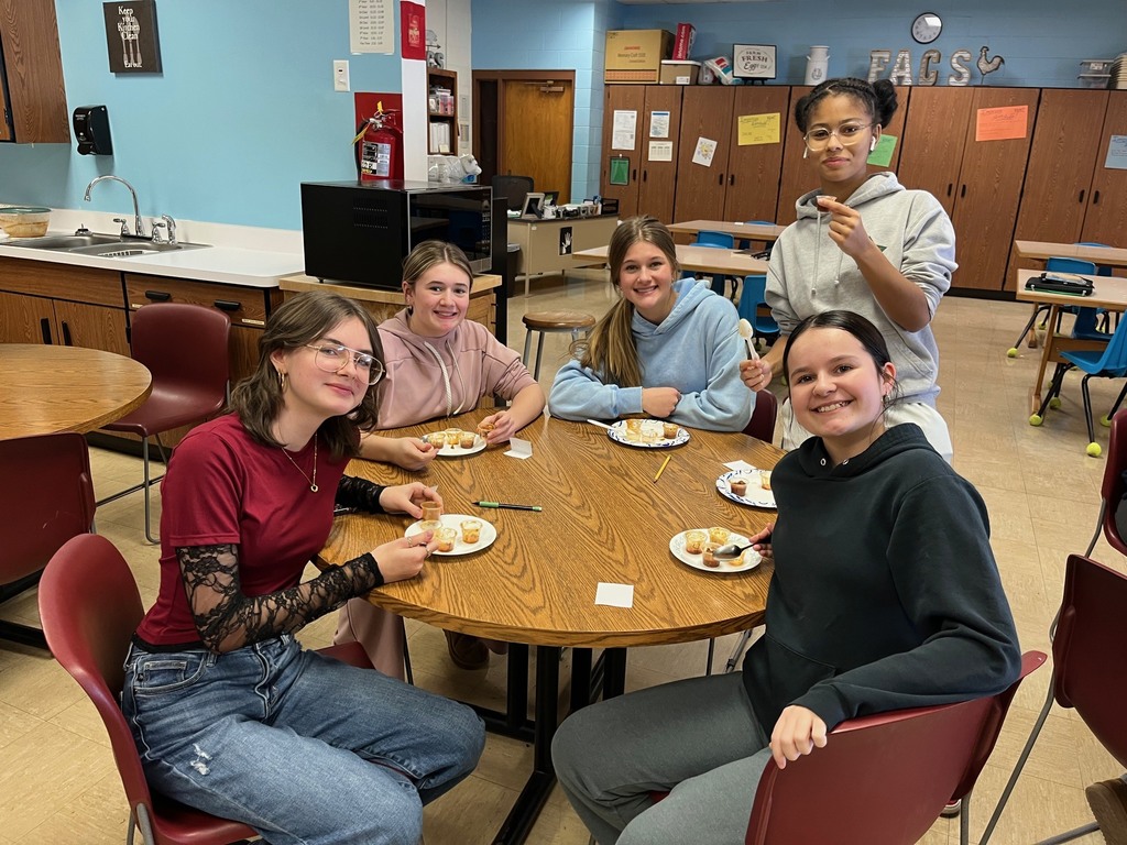 Students are testing the four different chilis. They are sitting around a table.