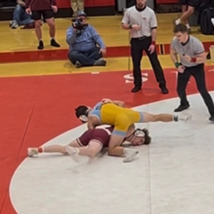 OM is pinning his opponent on the red, white and black mat  