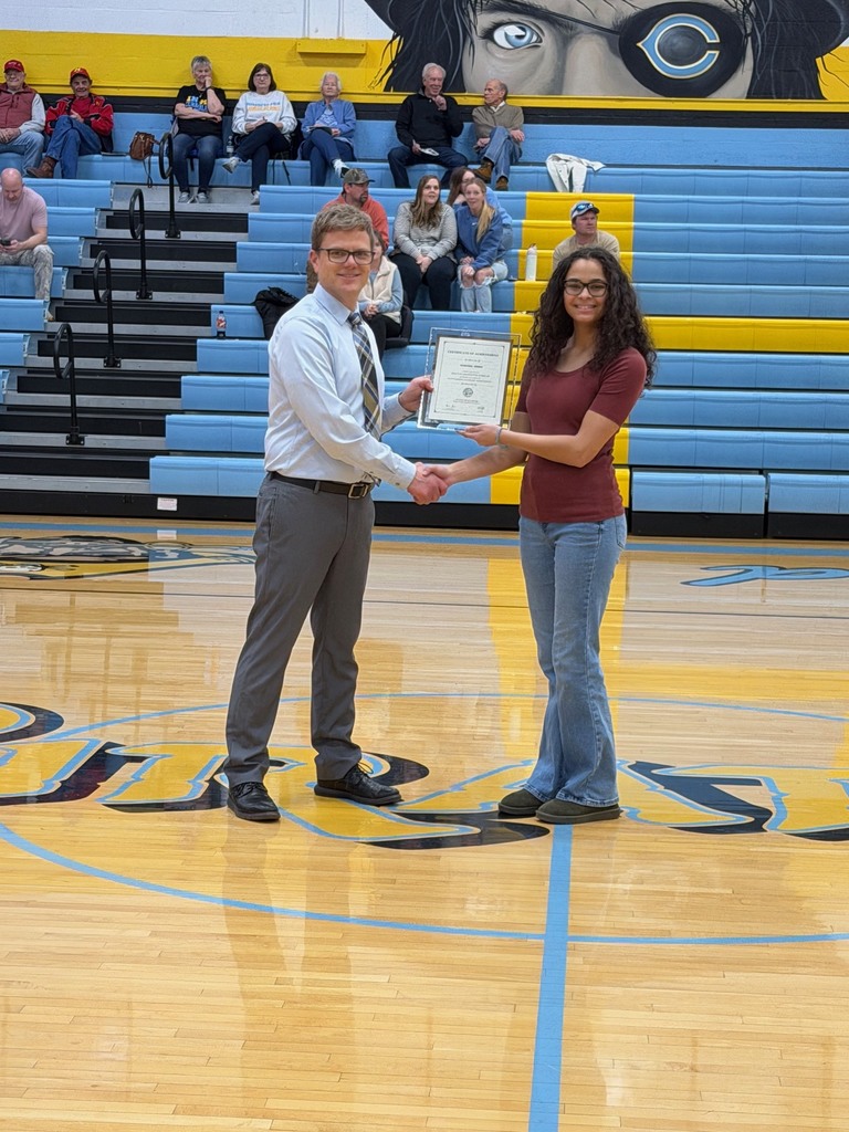 Pictured is AN accepting the certificate from Mr. Huffman, Principal, at center court. They are shaking hands and holding the certificate. 