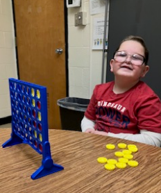 A student is playing Connect 4 as a speech activity.