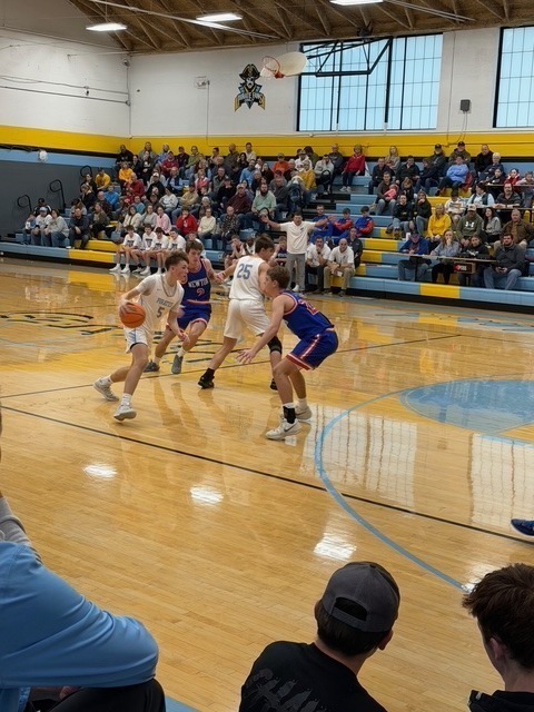RM is driving around a defender towards the basket. RM is starting just outside the right side of the arc.