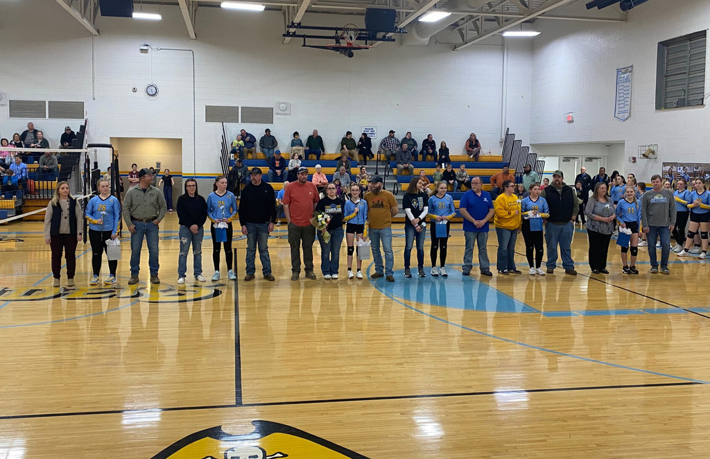 Pictured is the second half of the team standing in the center of the court. Each player has their parents standing on either side. 